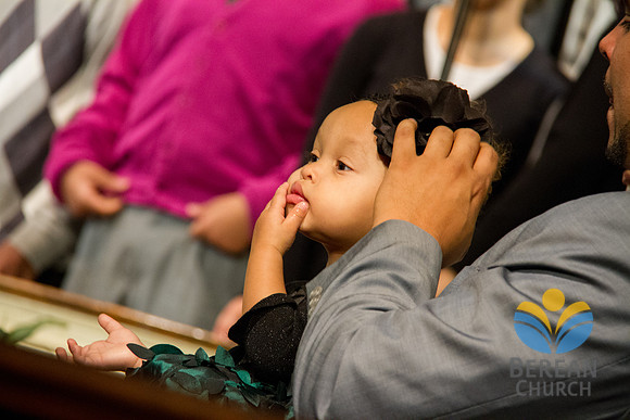 Pastor Boston adjusts the bow on his daughters head . (Official Berean SDA Church Photo by Burdie Henri)