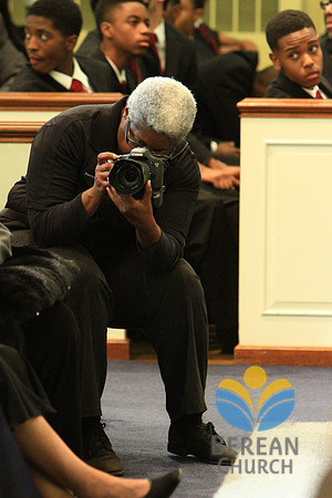 Burdie Henri,  of Berean's photography ministry, takes a photo of Urick LaDonis as Dr. Carton P. Byrd speaks